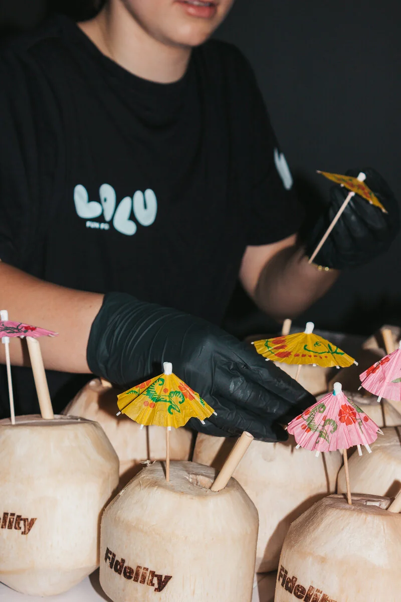 A fully branded Luv Coco coconut bar at a Fidelity Investments lobby activation in downtown Toronto - cart, signage, and coconuts styled to the brand.