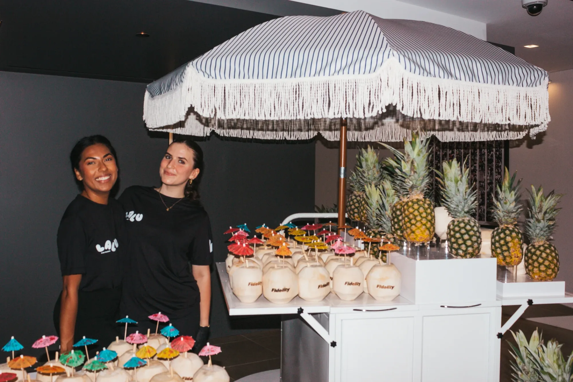 A custom-branded Luv Coco station at a corporate activation - coconuts stamped to the campaign, served by uniformed staff