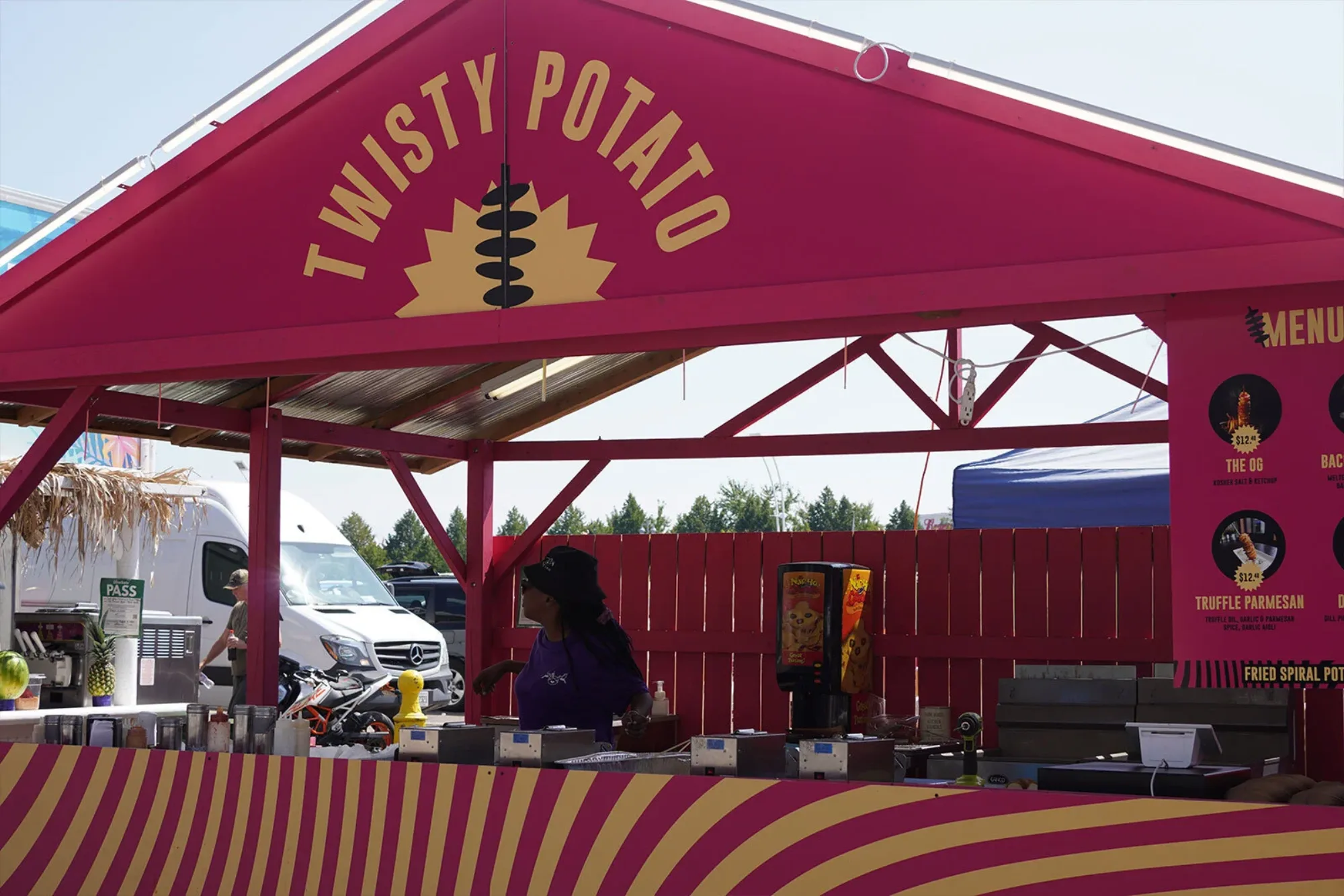 A branded Twisty Potato booth - spiral-cut potato on a stick, built for a fast festival line